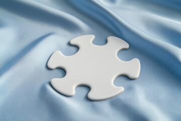 A white puzzle piece is on a blue fabric. The puzzle piece is missing a corner, and it is placed on a blue background. Concept of mystery and curiosity