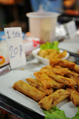 Por Pia Tod (Thai Fried Spring Rolls) for sale at food stall in night market in Thailand.