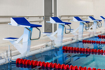 Starting blocks at a professional swimming competition pool with red lane dividers
