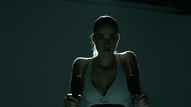 Zbliżenie na kobiete trenująca na rowerku stacjonarnym 