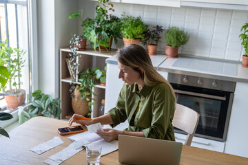 Exhausted pensive woman calculating utility bills on smartphone calculator. Financial pressure,...