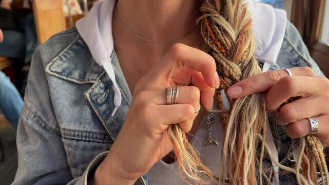 Braiding hairs with hands. Braids and dreadlocks. Modern hairstyle