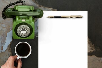 Man drinking coffee in front of paper and phone