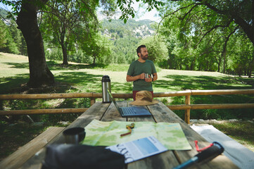 Man Enjoying Outdoor Adventure Amid Greenery and Relaxing Camp Setup