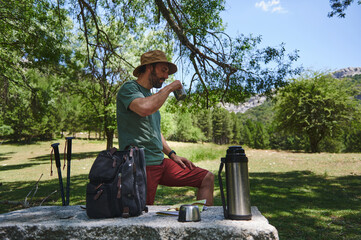 Traveler Relaxing with Drink Outdoors in a Scenic Mountain Setting