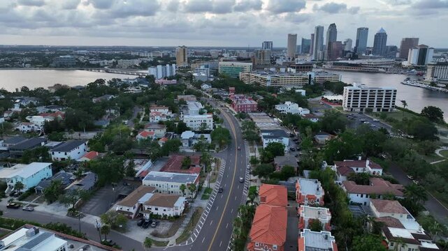 Traffic scene on road at bayshore of Tampa city at dusk. Aerial wide shot. Downtown skyline with Skyscrapers in distance. Florida, USA.