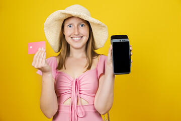 Smiling woman holding credit card and payment terminal for travel