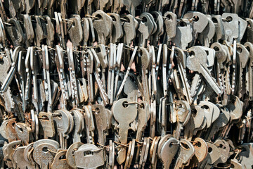 Close-up of a large collection of old metal keys tied together with wire. A textured background...