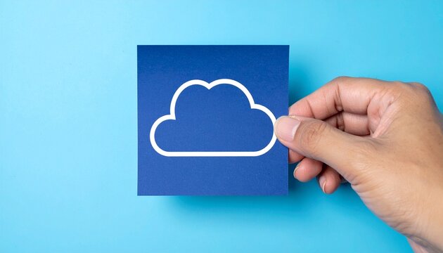 A person is holding a cloud icon in front of the sky blue background. This image evokes a sense of technological innovation and the future of data storage. The hand is holding the cloud icon