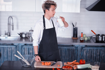 Asian cook in the kitchen prepares food in a cook suit