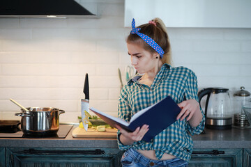 A cute young girl in the kitchen prepares food