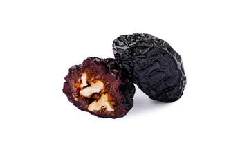 Dried black fruit with a split revealing its inner texture and seed