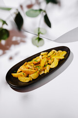Golden roasted potatoes with herbs on a serving plate