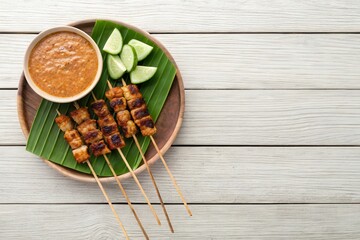 Delicious Satay with Peanut Sauce and Fresh Lime on Rustic Wooden Table Setup