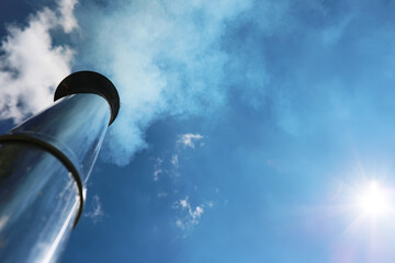 Chimney and smoke against the sky