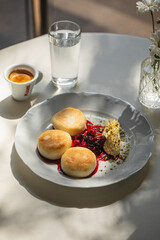 Portion of curd pancakes syrniki with berry jam and sour cream