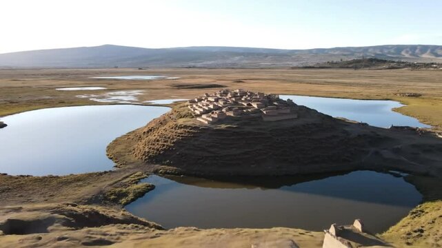 Ancient preinca tombs dot the landscape of sillustani, peru, with a serene lake reflecting the sky and the archaeological sites historical significance