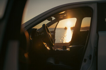 At dawn, I watched the sunrise over the sea through the car