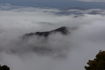 Mountain peak emerging from the fog that covers it