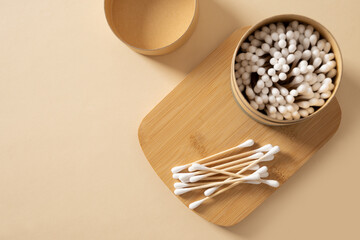 Wooden ecological cotton swab in paper container on beige background. Zero waste, sustainable...