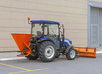 Tailgate Salt Spreader Orange Hopper and Snowplow at Blue Tractor Cleaning Parking