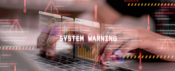 Hands typing on laptop with red system warning alert on screen. Concept of cybersecurity threat, digital error, data breach, hacking attempt, and real-time system monitoring.