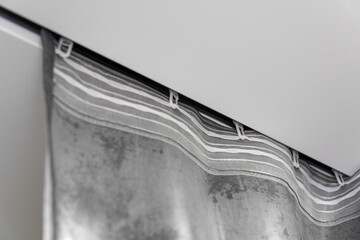 Close-up of the silver curtain hanging from the ceiling rail in the bathroom, creating a stylish and modern atmosphere.