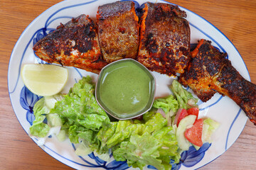 Tandoori trout fish grilled to perfection, served with tangy green chutney, lemon wedge, and fresh...