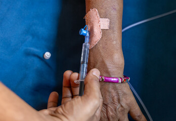 injection thorough cannula inserted in patient’s hand during daytime indoors