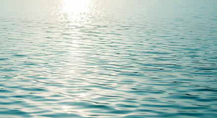 Rippled water surface with sunlight reflections in soft aqua and white tones