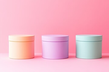 Three pastel-colored cylindrical containers against a vibrant pink background (1)