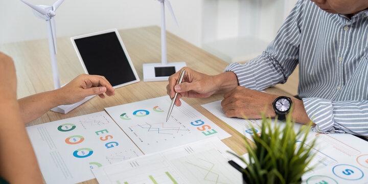 ESG Analysis. Business team reviewing charts and data for sustainable initiatives.
