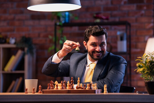 Indian executive playing chess in office, symbolizing business strategy and leadership planning - Powered by Adobe
