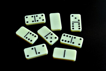 Playing domino stones on black background.