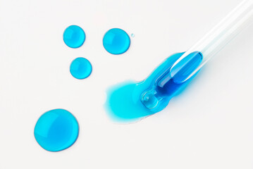 Drops of cosmetics and a pipette on a white background. A product for skin, face or hair care.