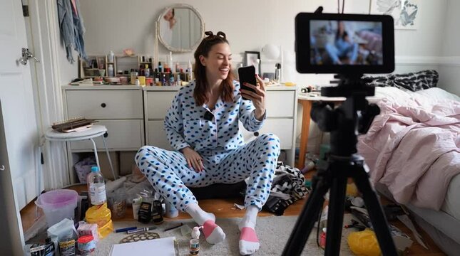 Young female influencer recording a GRWM (Get Ready With Me) video for social media, sitting on the floor and talking to her phone camera.

 - Powered by Adobe