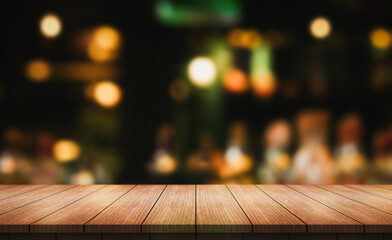 Empty wooden table top with lights bokeh on blur restaurant background.