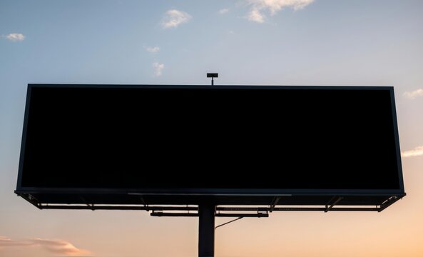 A sleek black horizontal billboard its face bathed in the soft light of a setting sun awaits the captivating message that will ignite the imaginations of passersby  professional presentation blank emp