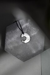 Crescent Moon Pendant on Stone Display. A Minimalist Jewelry Still Life for Creative Projects.
