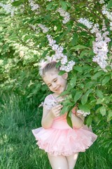 Portrait of Enchanting Little Girl in Pink Tutu Enjoying Lilac Blossoms in Serene Garden Setting.