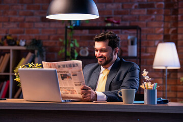 Executive reads business paper at desk, showing focus, awareness, and interest in financial updates