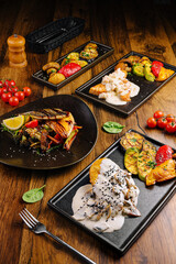 Grilled vegetable and seafood platters served with sauce on wooden table