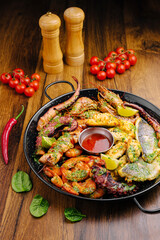 Grilled seafood platter with fresh vegetables and spices on wooden table