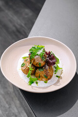 Deliciously crafted savory potatoes garnished with greens on a sleek table