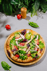 Fresh salad pizza topped with chicken, vegetables, and herbs