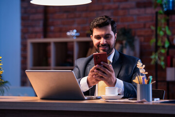 Corporate man typing on phone at work desk, representing modern business communication and focus