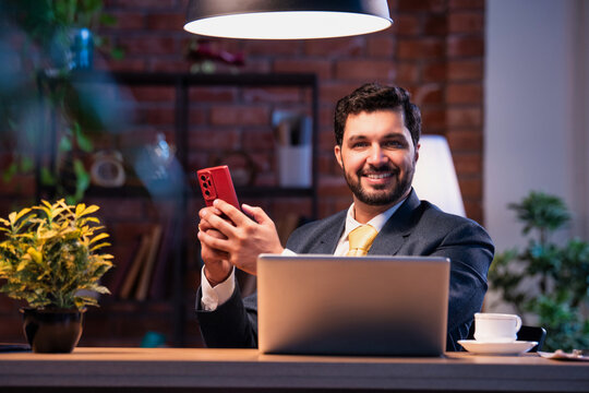 Corporate man typing on phone at work desk, representing modern business communication and focus
