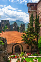 Historic monastery courtyard with flowers and mountain view in Meteora Greece