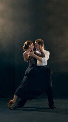 A graceful pair engages in a passionate embrace during a captivating Argentine tango dance performance. Concept of romance and cultural expression through movement.