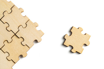 Wooden puzzle pieces and a completed jigsaw puzzle with white background. concept of comparison or...